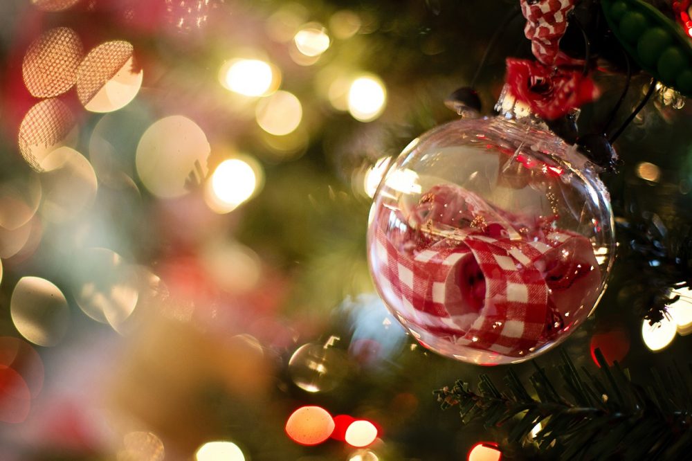 closeup of a clear christmas ornament on a tree with metal decor on the inside